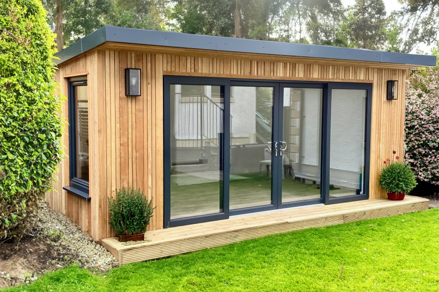 Unique vertical wooden cladded garden room with anthracite patio doors and wood decking