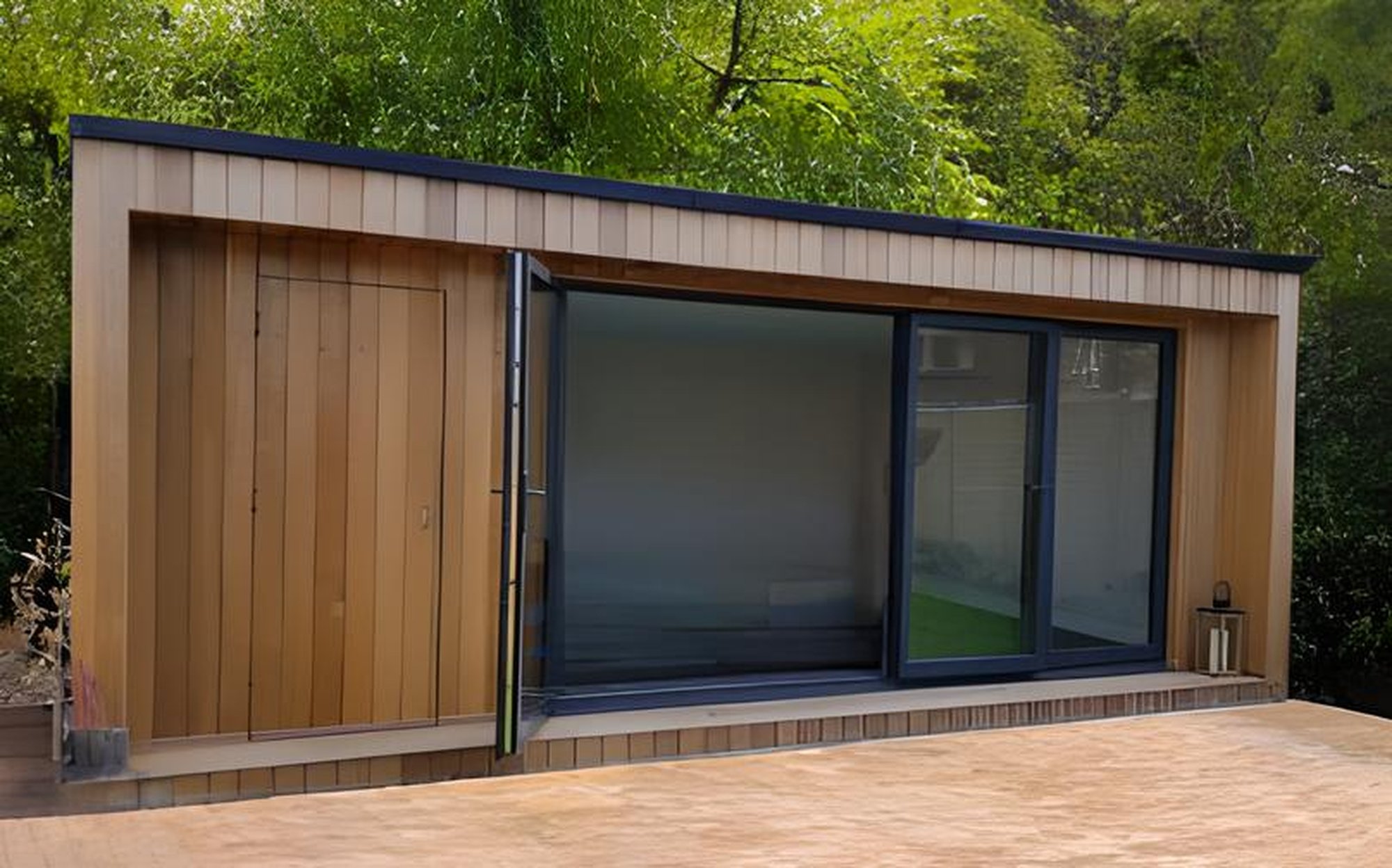 Garden Room with vertical wood cladding, anthracite bifold doors and block pathed drive, located in a wooded garden